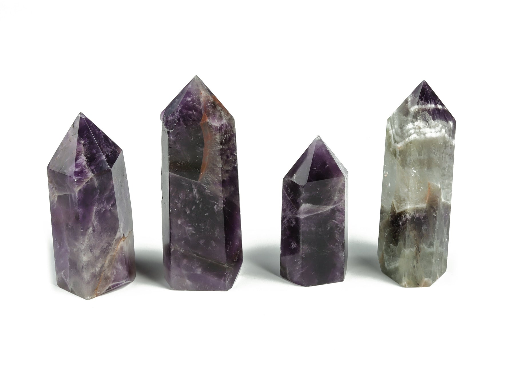 Dream Amethyst obelisk tower crystal from GemstoneGO, showcasing a purple gemstone with natural crystal formations and a pointed top.