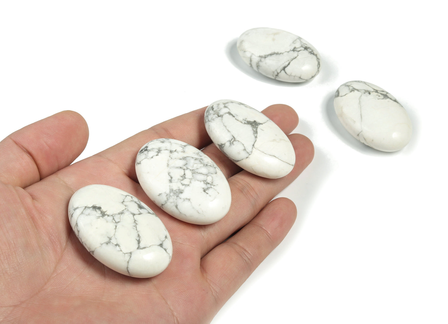 Howlite palm gemstone spa stone, 45x35mm, from GemstoneGO, showcasing a smooth, polished white and gray patterned healing stone.