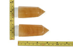 Orange Calcite obelisk tower crystal from GemstoneGO, showcasing its vibrant orange color and smooth, pointed shape.
