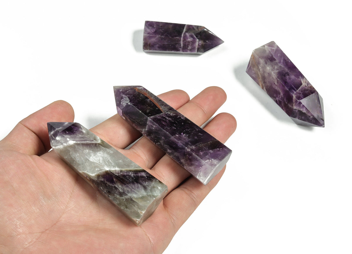 Dream Amethyst obelisk tower crystal from GemstoneGO, showcasing a purple amethyst gemstone carved into a tall, pointed obelisk shape.