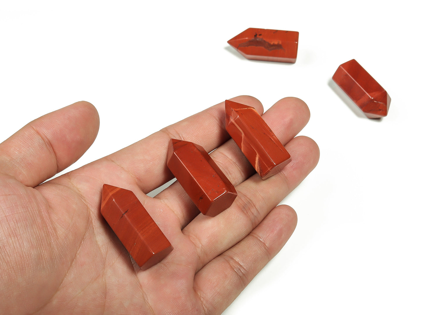 Red Jasper obelisk tower crystal from GemstoneGO, 35mm tall, showcasing a vibrant red stone with natural striations and a pointed tip.