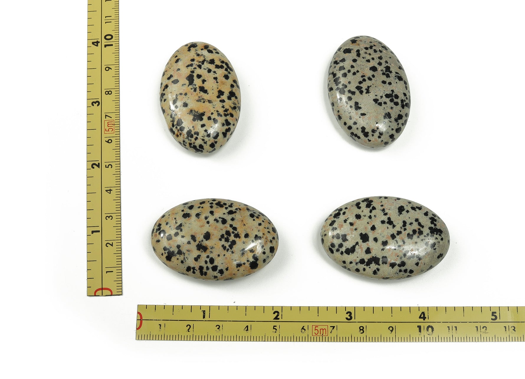 Dalmatian Jasper palm gemstone spa stone, 45x35mm, showing black spots on cream-colored stone with smooth, polished surface.