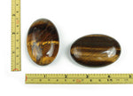 Tiger Eye palm gemstone spa stone, 60x40mm, showing polished, smooth surface with rich golden-brown and chatoyancy features.