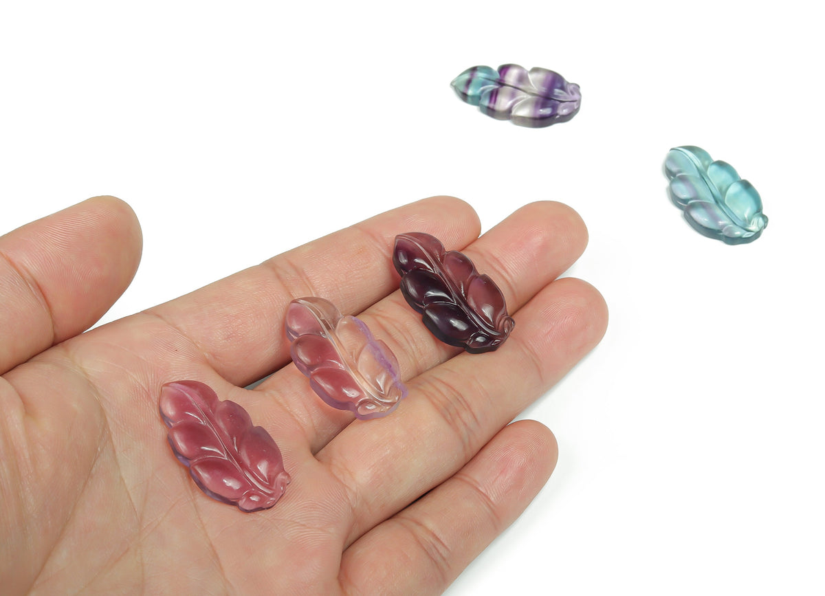 Fluorite leaf-shaped gemstone carving by GemstoneGO, vibrant green and purple hues with detailed leaf design.