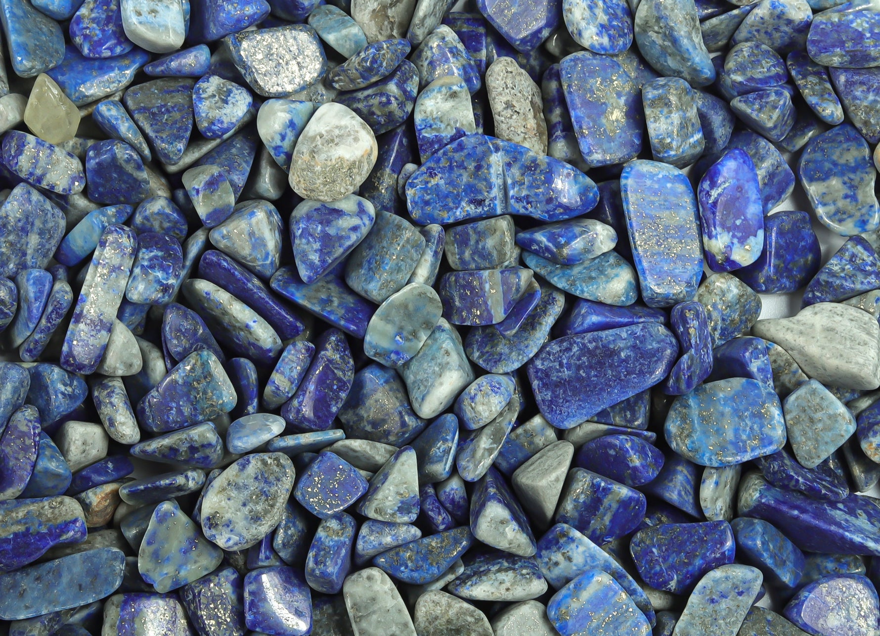 Lapis Lazuli crystal chips, semi-tumbled stones in 7-12mm size, from GemstoneGO, shown in a bulk package.