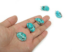 Turquoise crystal pendant with silver edge and turquoise gemstones, showcasing a detailed silver setting and vibrant blue turquoise stones.