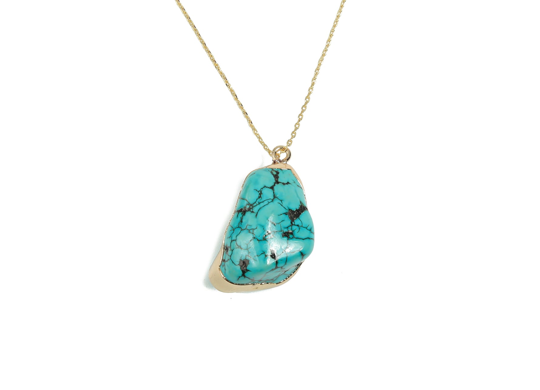 Turquoise crystal pendant with healing stones, featuring a silver setting, displayed on a neutral background.