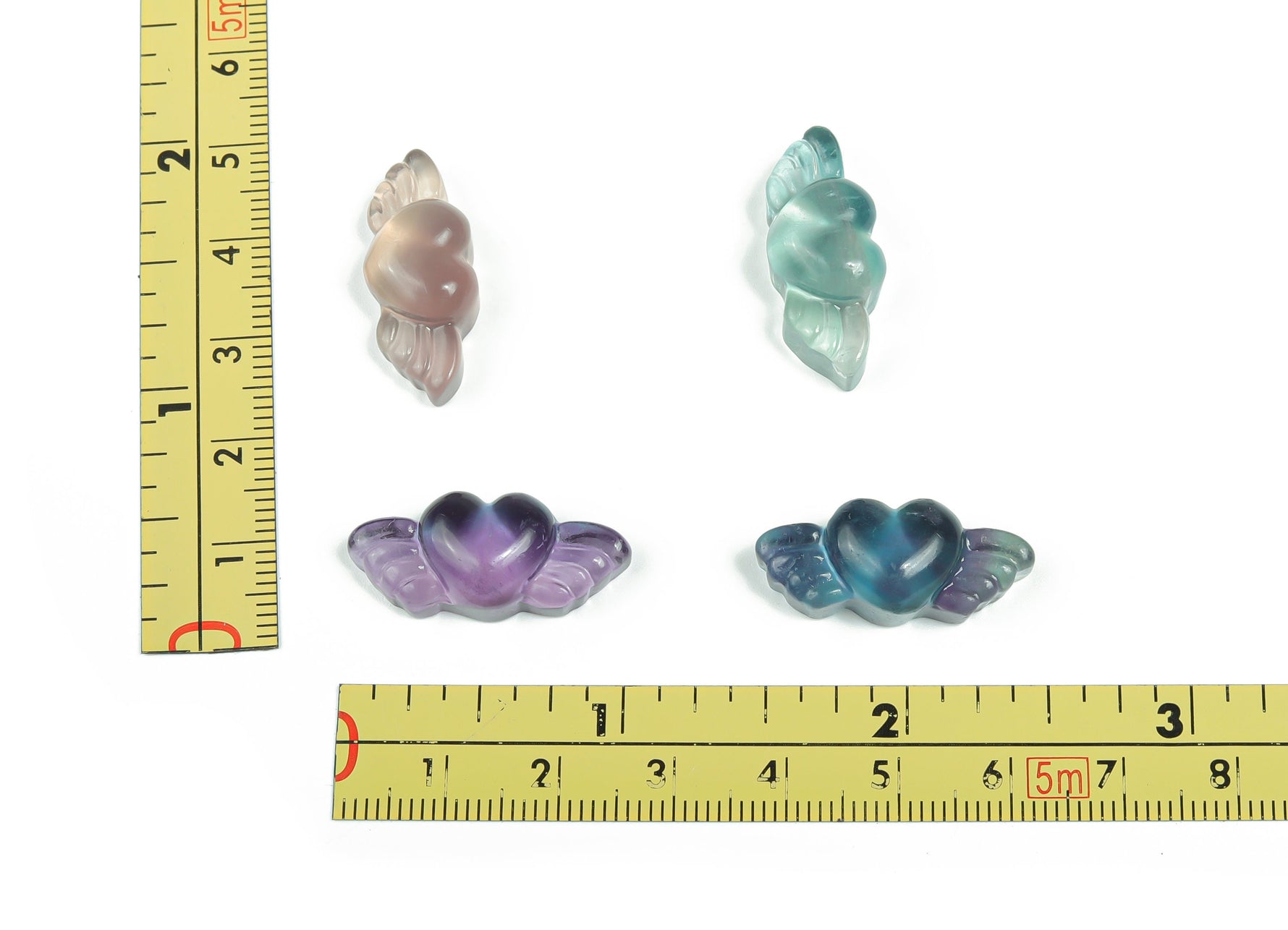 Fluorite wing heart gemstone carving by GemstoneGO showing a colorful, detailed heart-shaped pendant with wing accents.