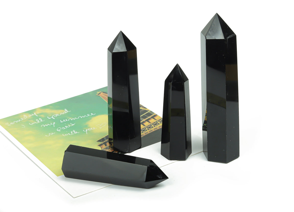 Polished black obsidian obelisk tower crystal from GemstoneGO, standing upright with a smooth, shiny surface.
