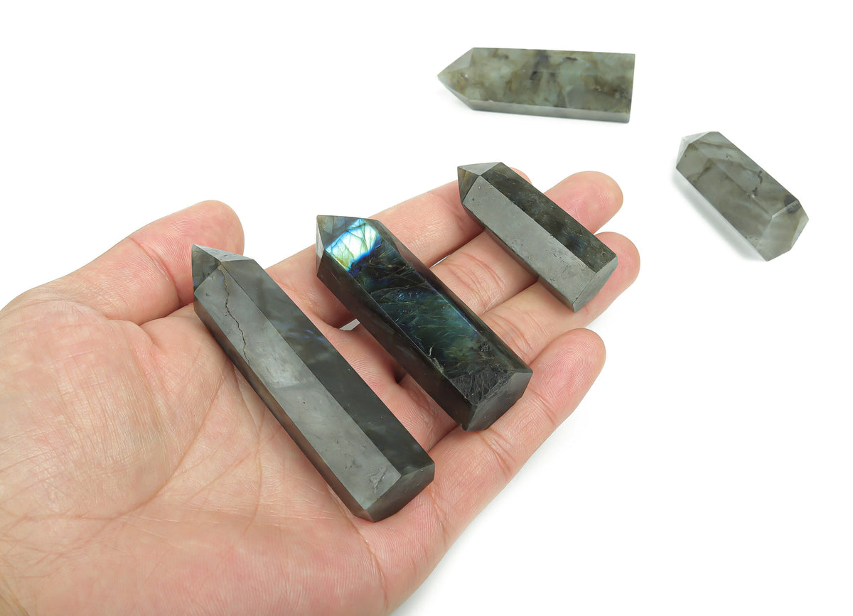 Labradorite obelisk tower crystal from GemstoneGO showcasing iridescent stone with natural mineral patterns and a pointed top.