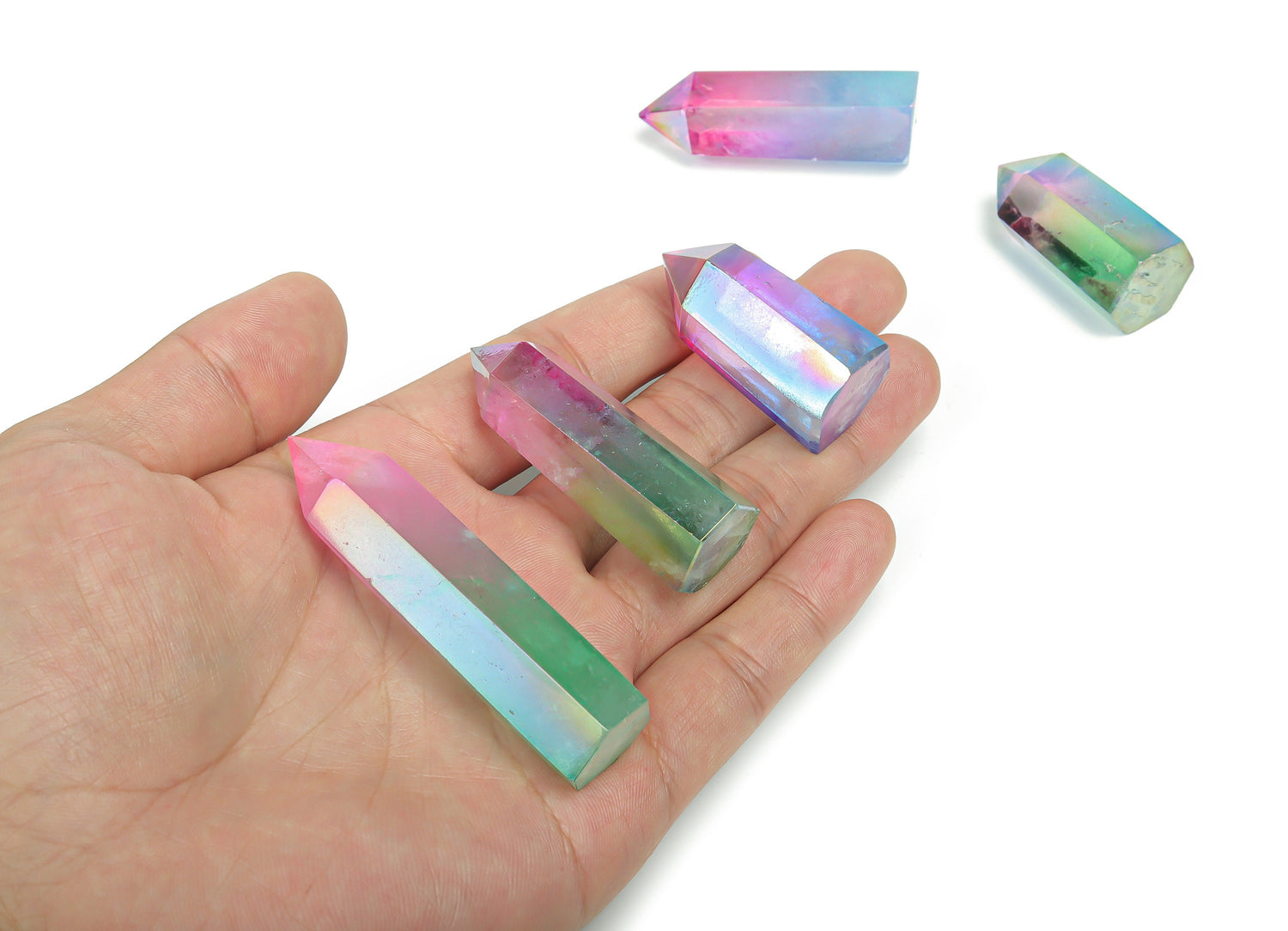 Rainbow Aura Quartz obelisk tower crystal from GemstoneGO, showcasing vibrant rainbow colors and polished stone with a pointed top.
