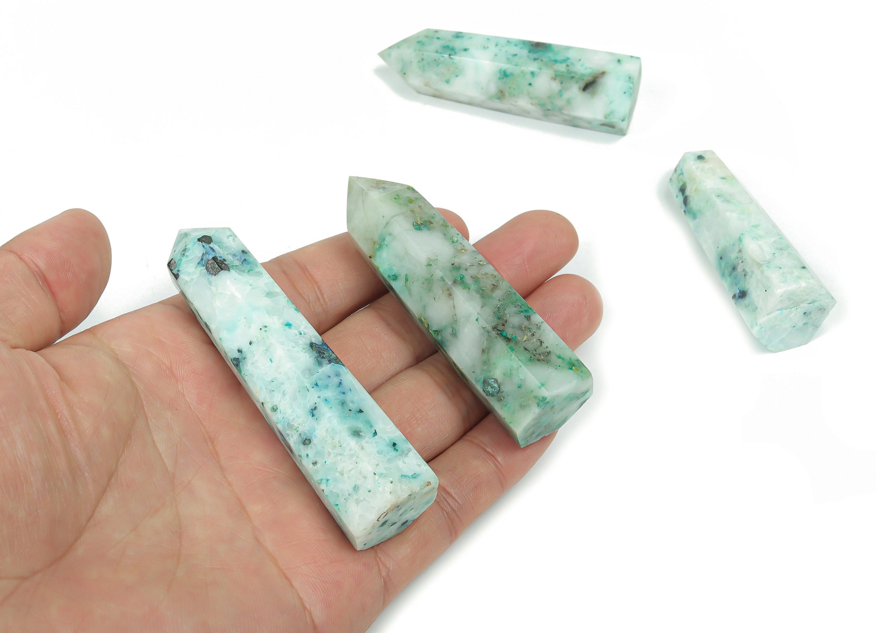 Phoenix Obelisk Tower Crystal from GemstoneGO, a polished clear quartz gemstone sculpture with detailed carving and a pointed top.