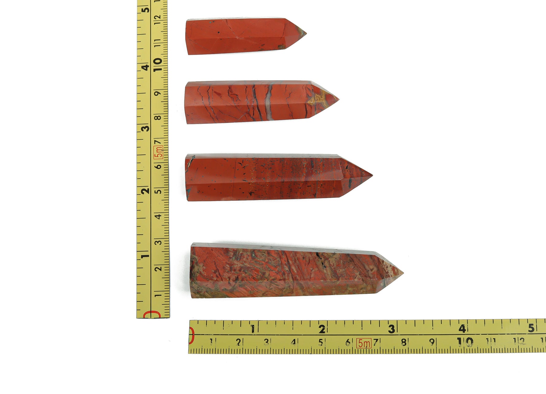 Red Jasper obelisk tower crystal from GemstoneGO, showcasing a polished red stone with natural striations and a pointed top.