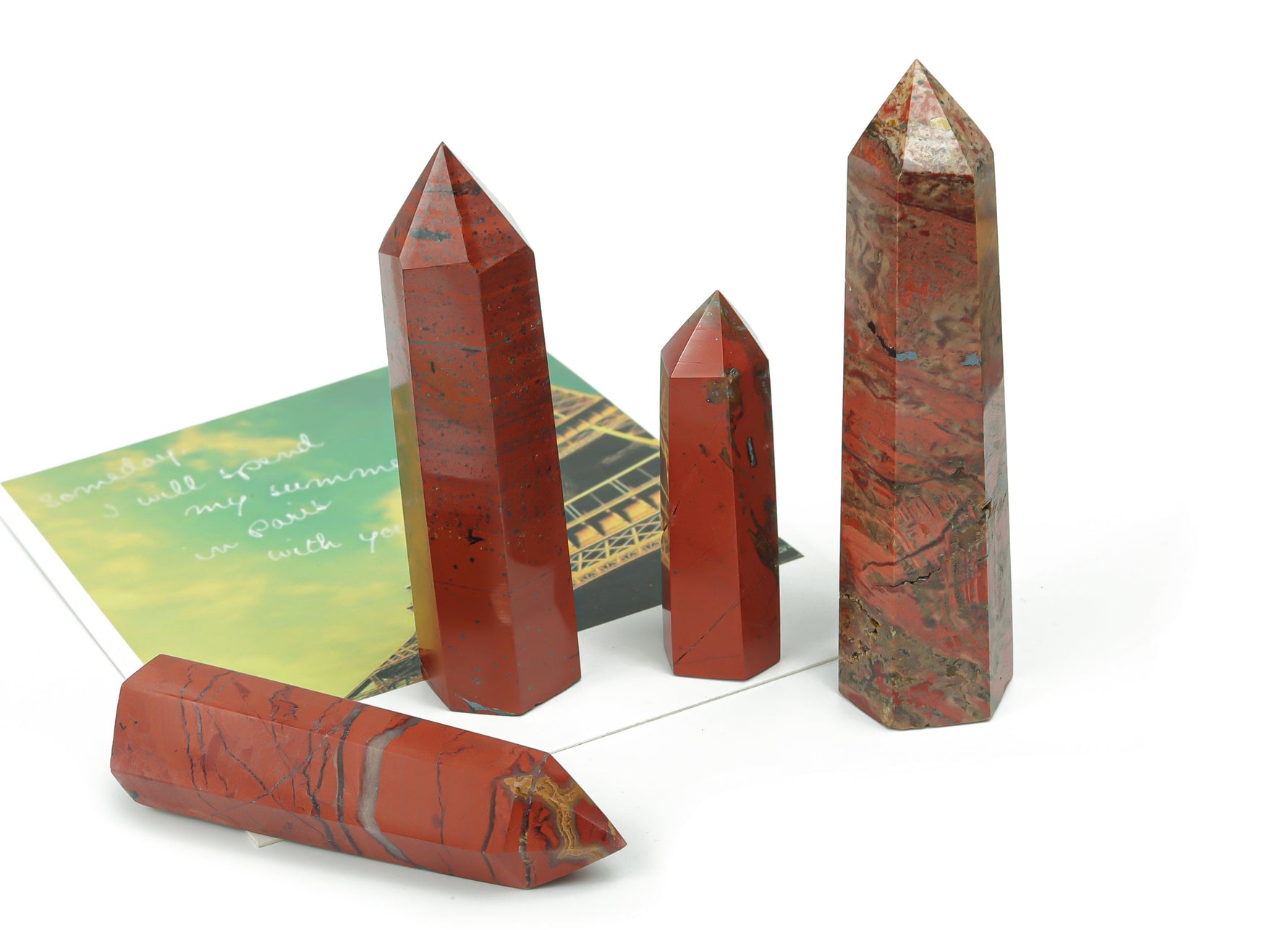 Red Jasper obelisk tower crystal from GemstoneGO showcasing a polished red stone sculpture with natural patterns and a pointed top.
