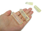 Lemon citrine quartz obelisk tower crystal from GemstoneGO, showcasing a bright yellow gemstone with a pointed top and smooth facets.