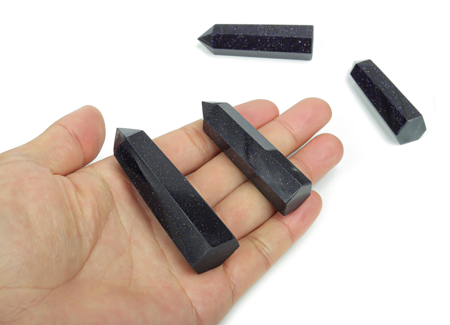 Blue Goldstone obelisk tower crystal from GemstoneGO, showcasing a polished, deep blue and gold-speckled gemstone sculpture.