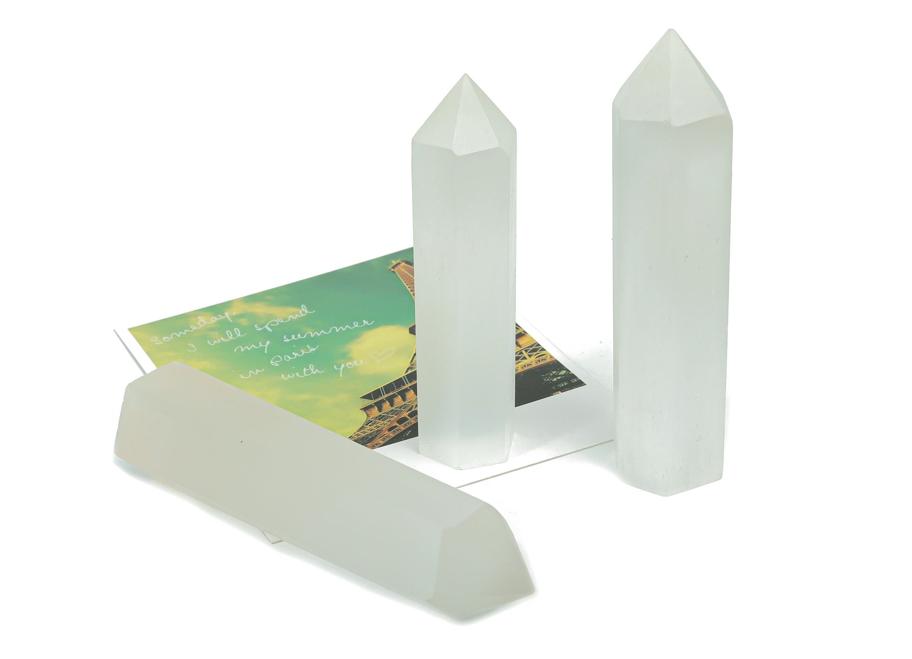 Selenite obelisk tower crystal by GemstoneGO, tall white mineral with smooth polished surface and natural crystal facets.