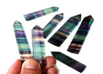 Rainbow fluorite obelisk tower crystal by GemstoneGO, featuring vibrant rainbow colors and polished stone surface.