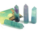 Bright green fluorite obelisk tower crystal from GemstoneGO, showcasing a smooth, polished gemstone with vibrant color and natural striations.