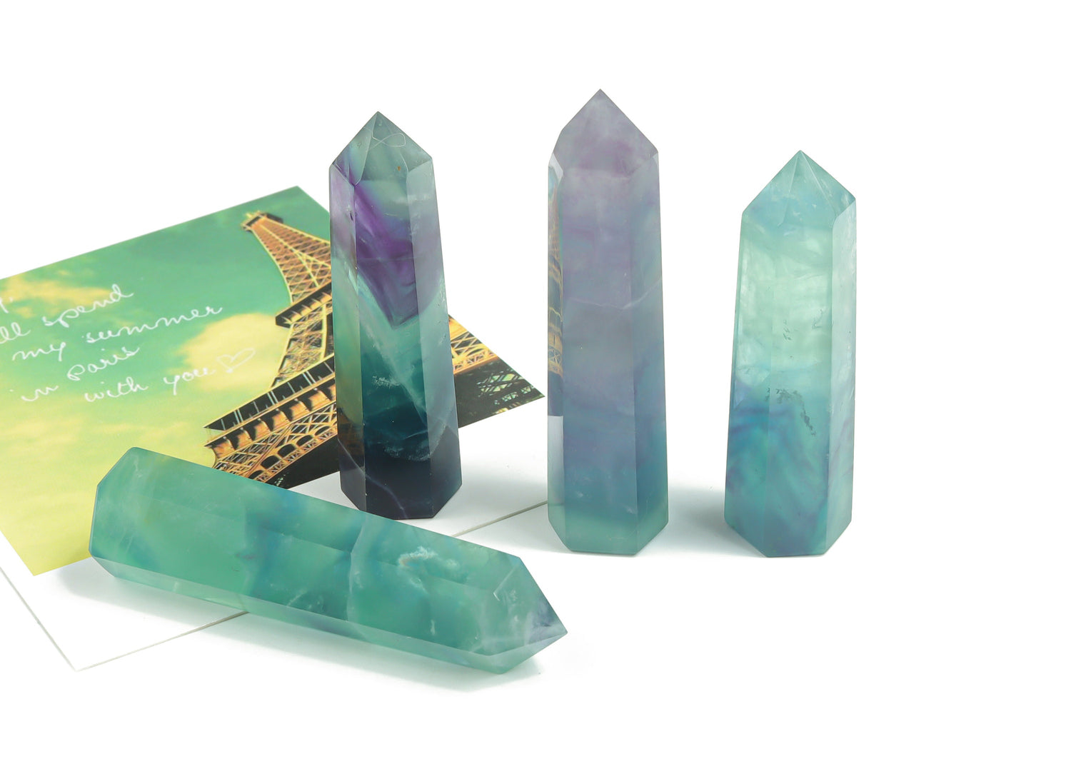 Bright green fluorite obelisk tower crystal from GemstoneGO, showcasing a smooth, polished gemstone with vibrant color and natural striations.