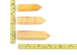 Yellow aventurine obelisk tower crystal from GemstoneGO, showcasing a polished yellow stone with a pointed obelisk shape.