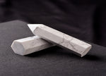 Howlite obelisk tower crystal from GemstoneGO, showcasing a smooth white stone with gray veining and a pointed top.