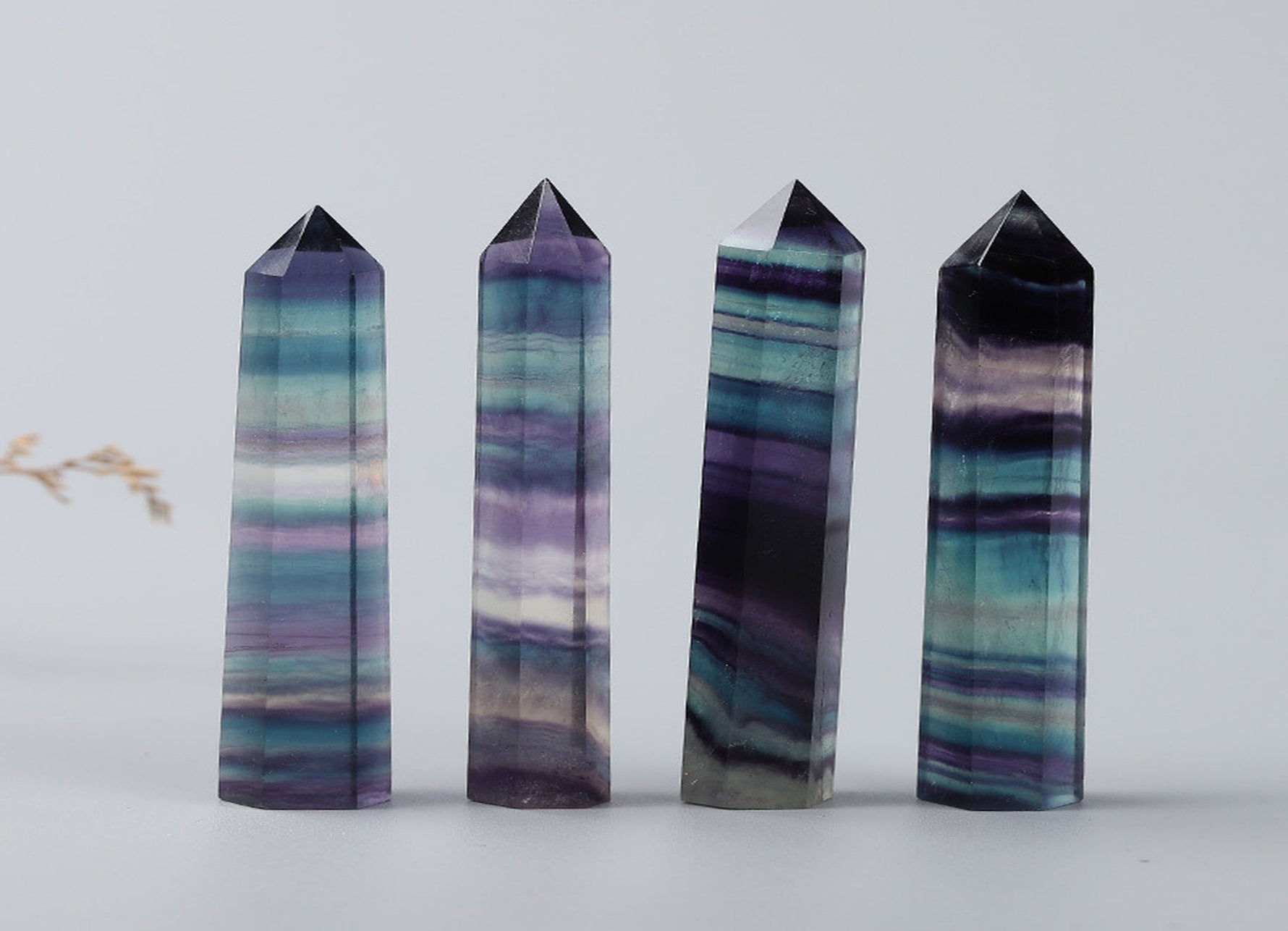 Rainbow fluorite obelisk tower crystal from GemstoneGO, showcasing vibrant rainbow colors and polished stone surface.