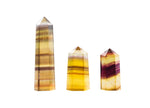 Yellow fluorite obelisk tower crystal from GemstoneGO, polished yellow gemstone with a pointed obelisk shape and natural crystal details.