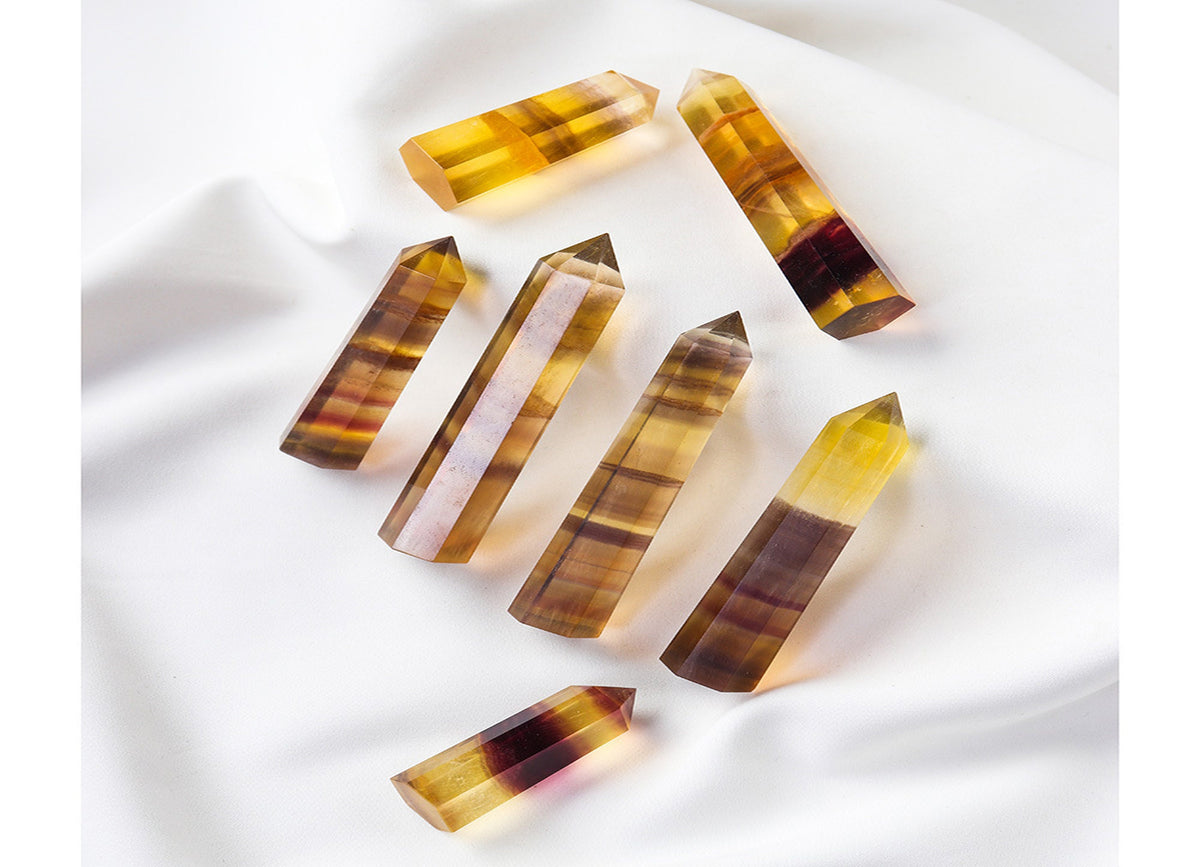 Yellow fluorite obelisk tower crystal from GemstoneGO, showcasing a smooth, polished yellow mineral with natural striations and clarity.