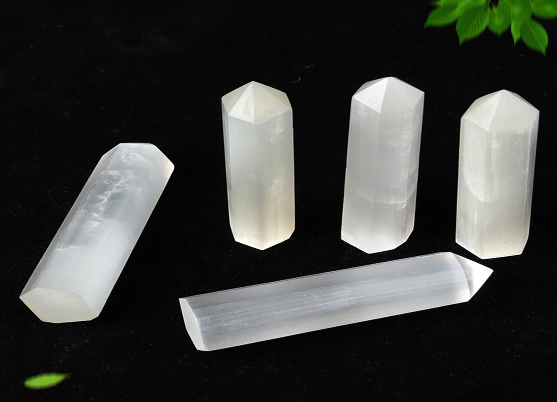 Selenite obelisk tower crystal by GemstoneGO, showcasing a smooth, white mineral structure with natural striations and polished surface.