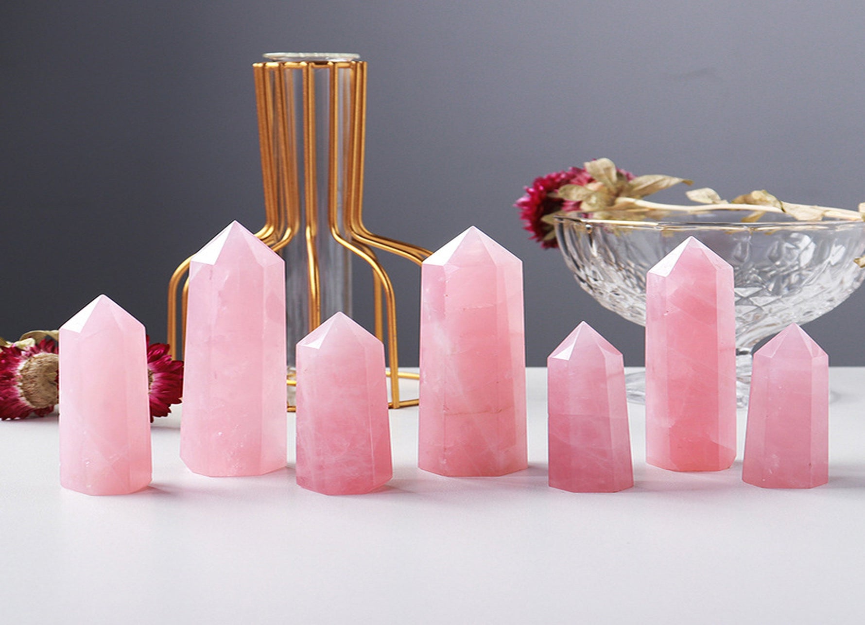 Rose Quartz obelisk tower crystal from GemstoneGO, showing a pink, polished gemstone with natural striations and smooth facets.
