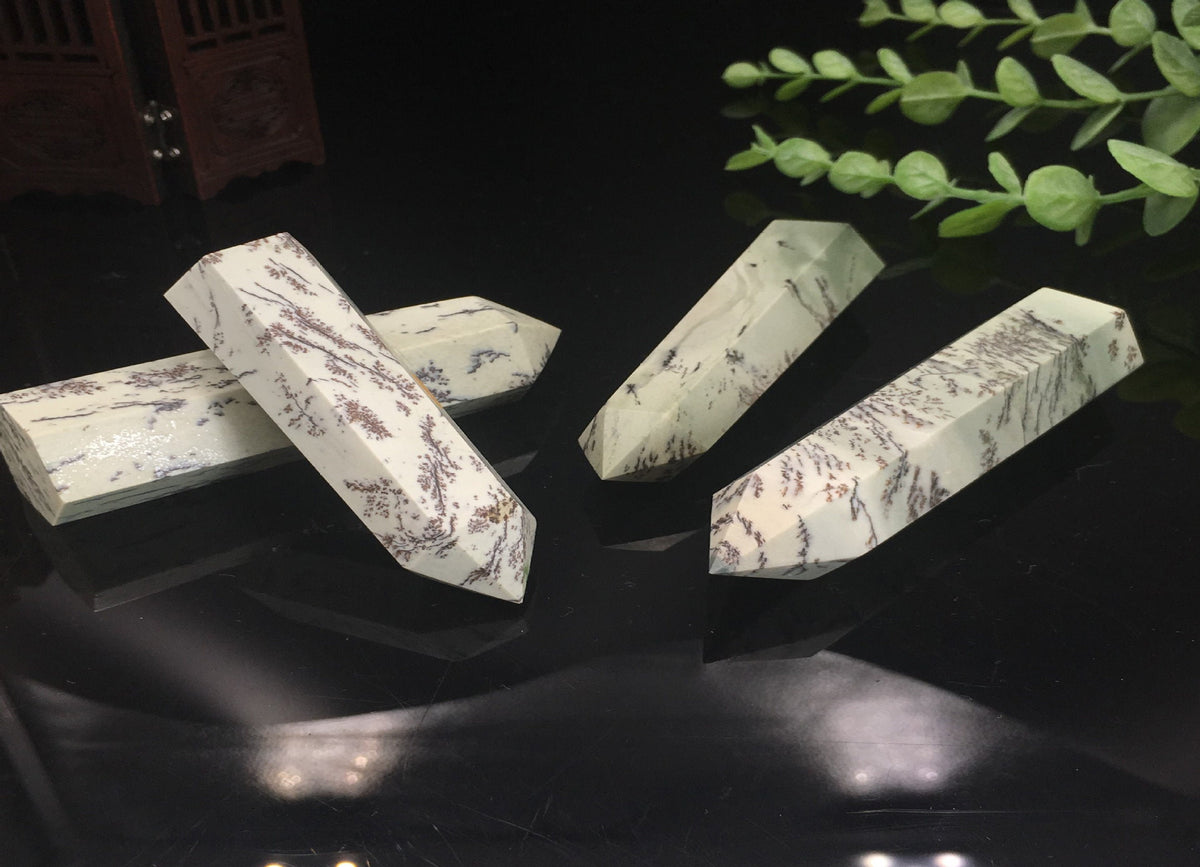 Dendritic jade obelisk tower crystal from GemstoneGO showing a green jade stone with natural dendritic patterns and a pointed shape.