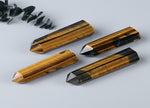 Tiger Eye obelisk tower crystal from GemstoneGO, showcasing polished golden-brown stone with smooth, pointed shape.