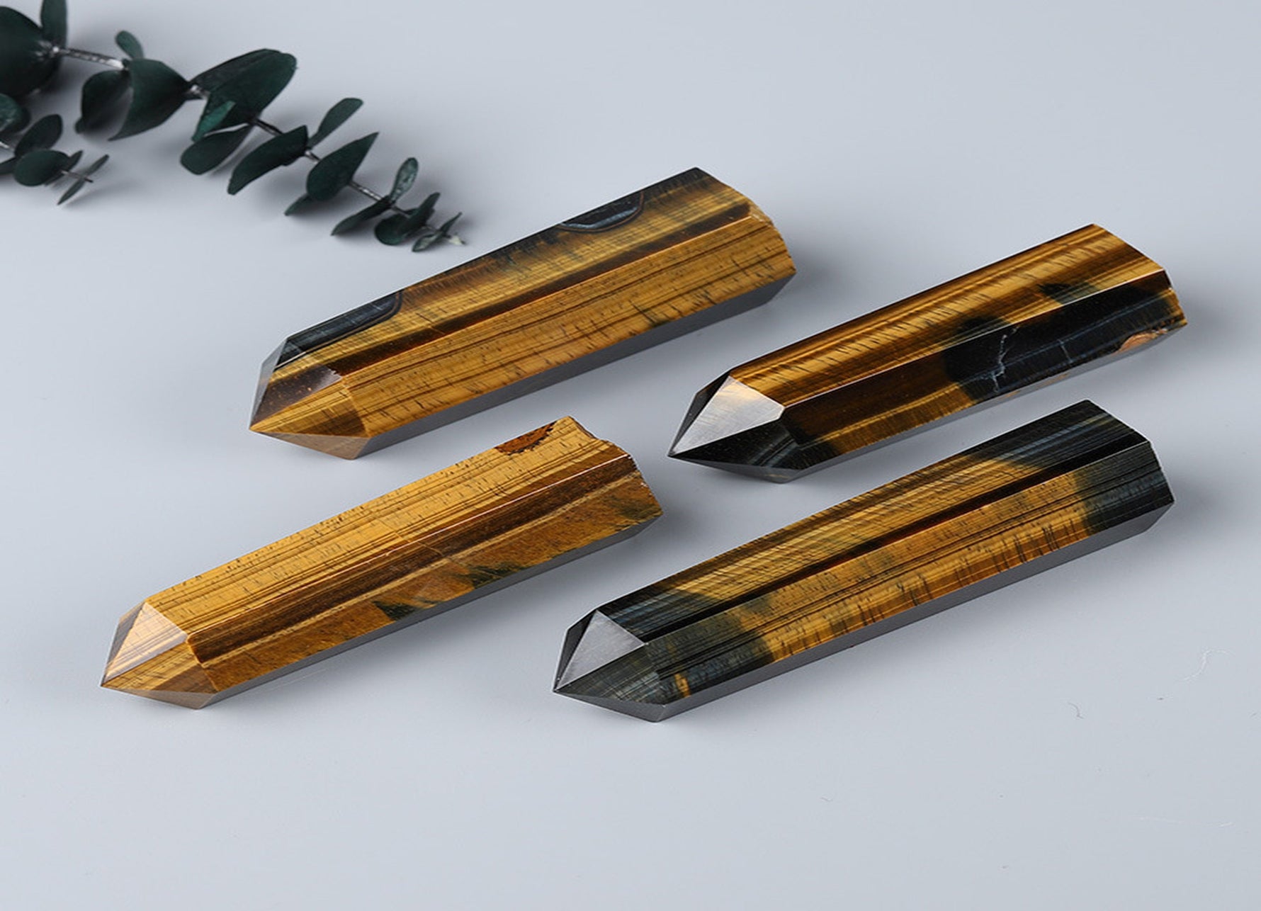 Tiger Eye obelisk tower crystal from GemstoneGO, showcasing polished golden-brown stone with smooth, pointed shape.