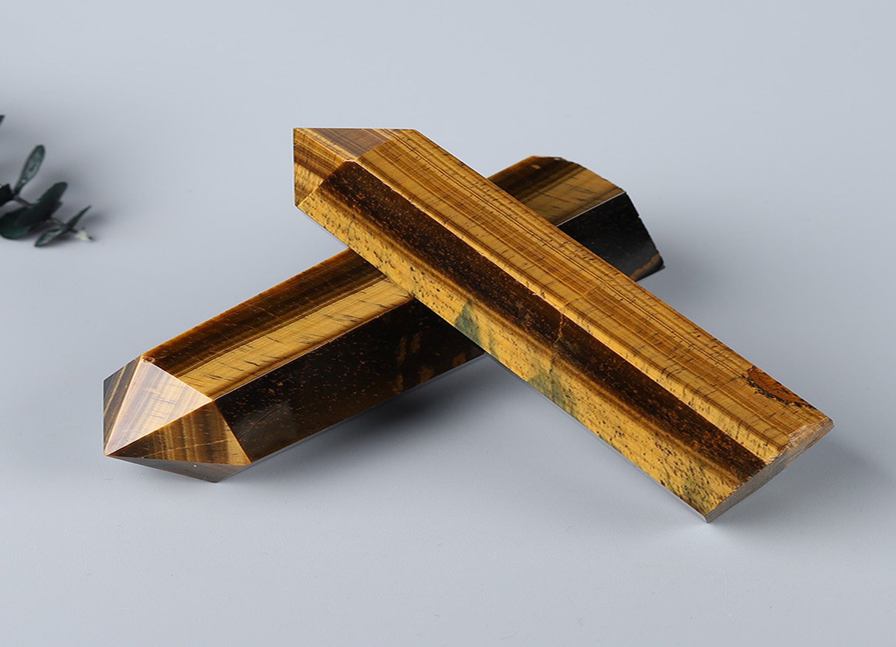 Tiger Eye obelisk tower crystal from GemstoneGO featuring a polished golden-brown stone with natural banding and a pointed top.