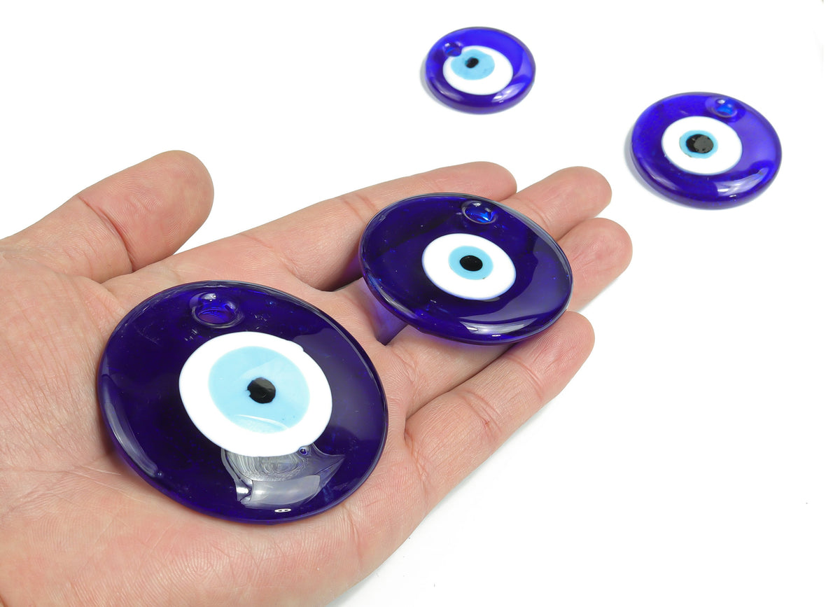 Blue glass evil eye pendant with hole, designed for jewelry or home decor, featuring a protective evil eye symbol from GemstoneGO.