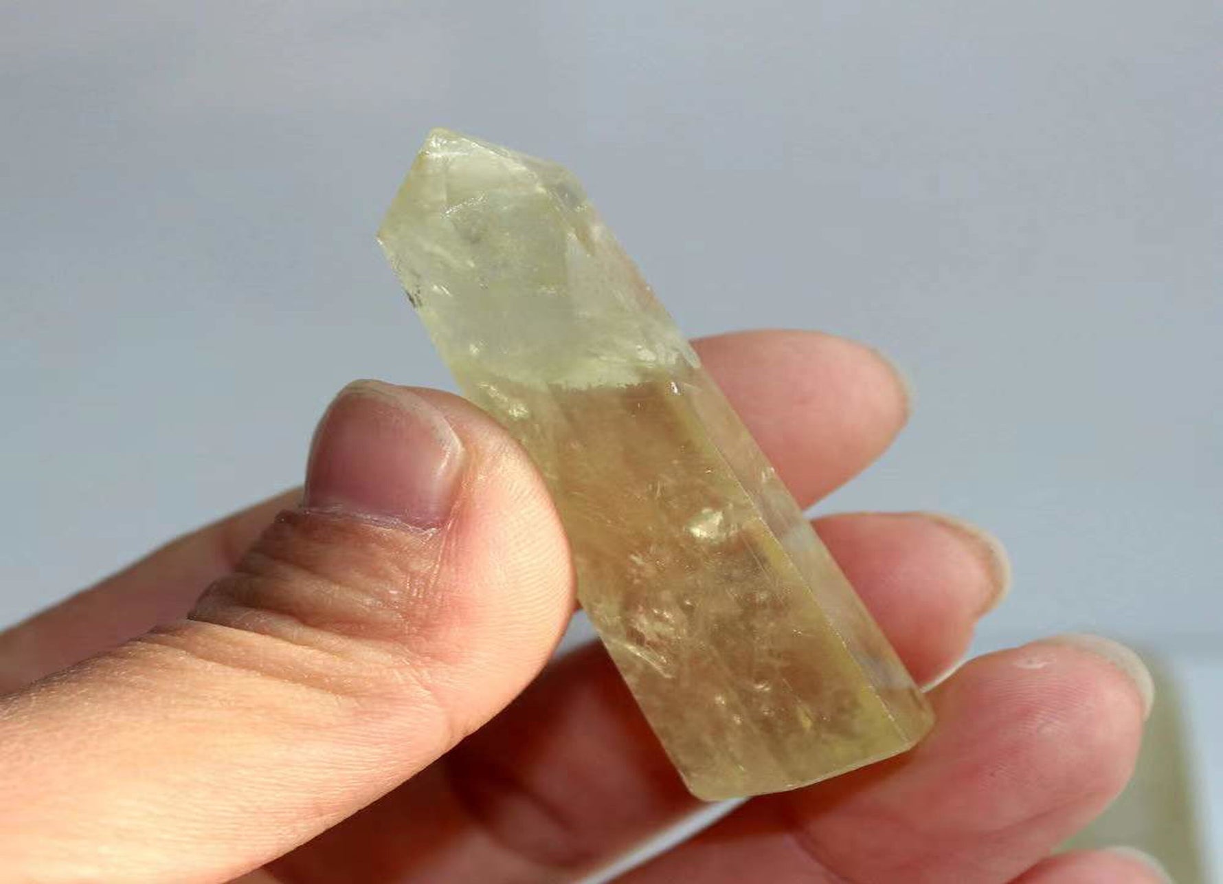 Citrine obelisk tower crystal from GemstoneGO, showing a polished yellow-orange gemstone with natural crystal formations and smooth facets.