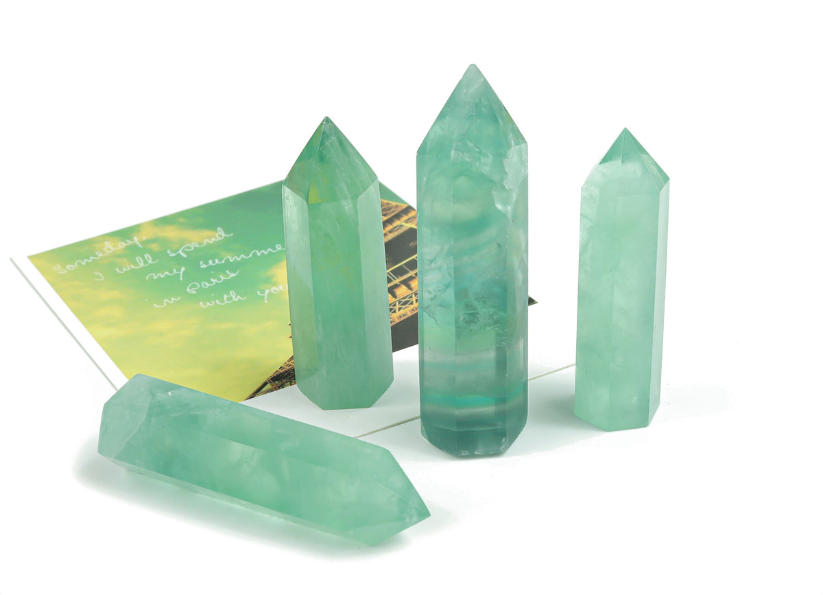 Green fluorite obelisk tower crystal from GemstoneGO, showcasing a polished green mineral with vertical faceted sides.
