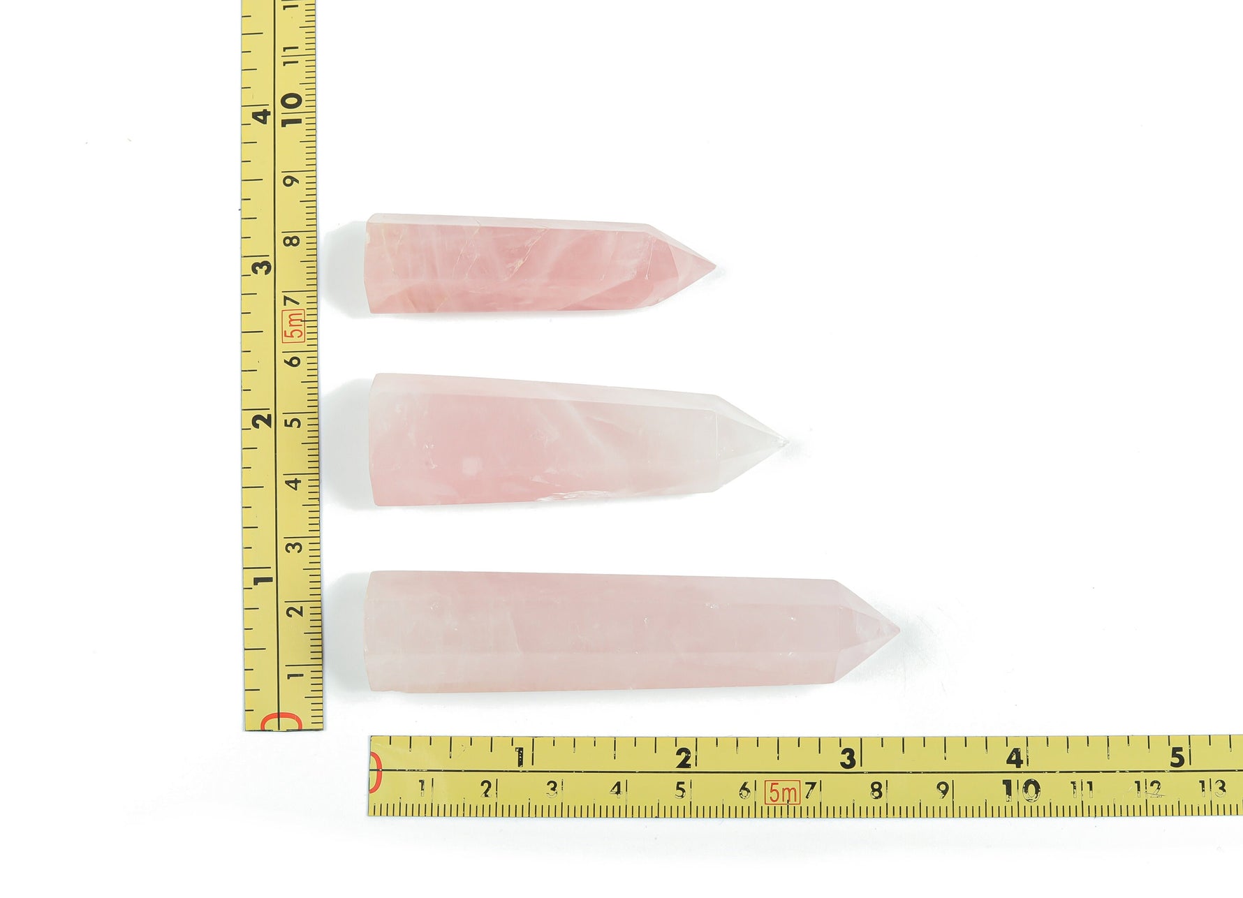 Rose quartz obelisk tower crystal from GemstoneGO, featuring a pink, polished stone with natural crystal details and a pointed top.