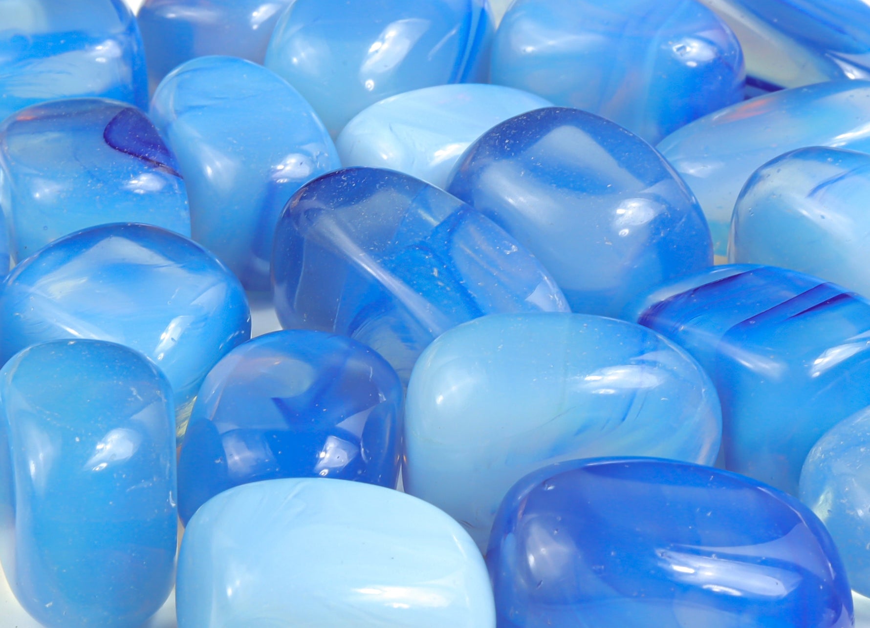 Blue opalite tumbled stone from GemstoneGO, smooth polished gemstone with a vibrant blue hue and subtle glow.