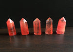 Cherry Quartz obelisk tower crystal by GemstoneGO, showing a polished red-pink gemstone with pointed top and smooth sides.