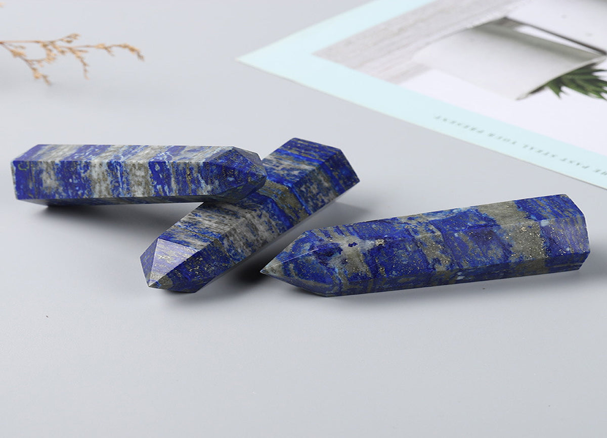 Lapis Lazuli obelisk tower crystal from GemstoneGO, showcasing deep blue stone with golden pyrite inclusions on a white background.