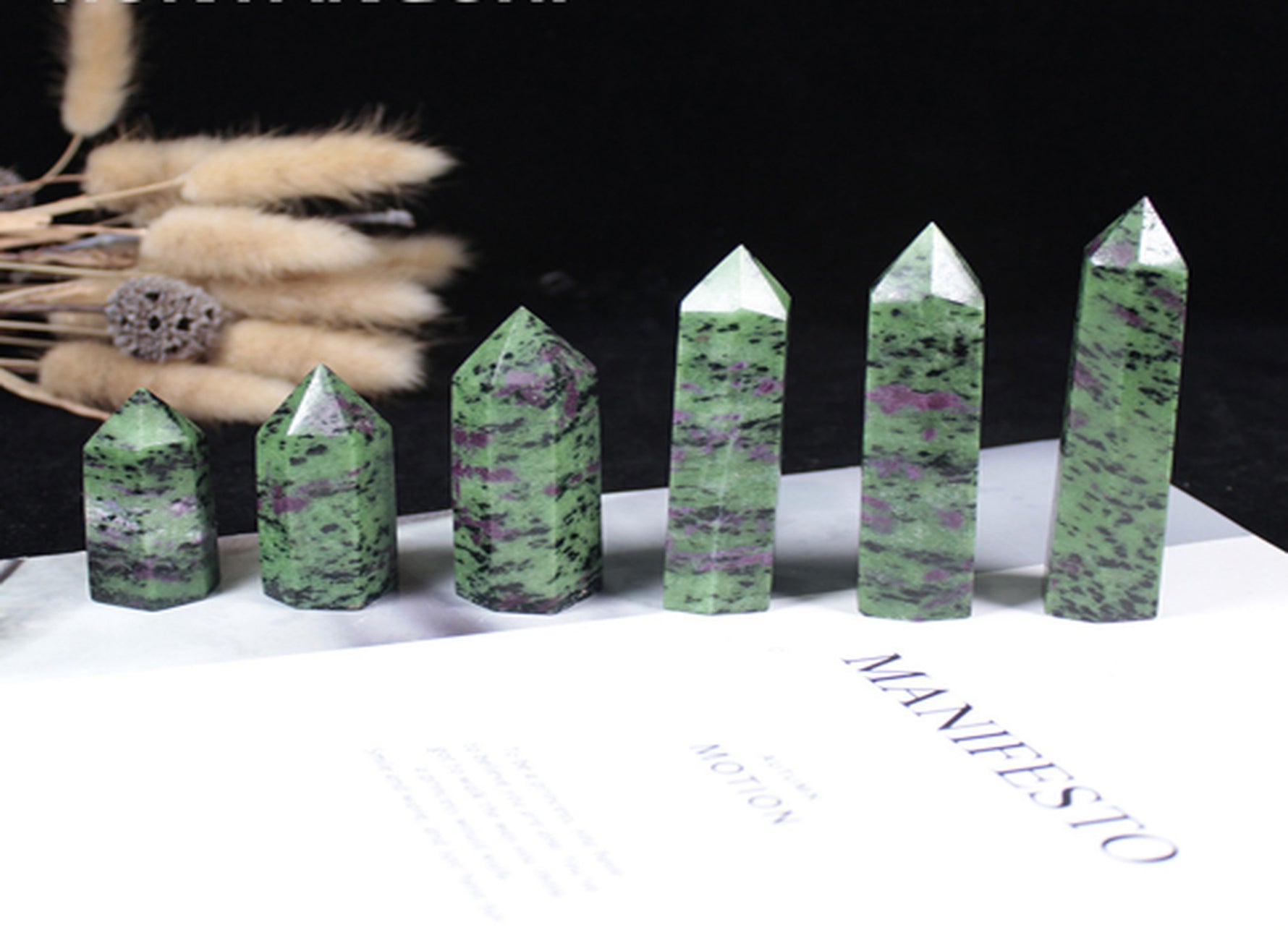 Ruby Zoisite obelisk tower crystal from GemstoneGO featuring vibrant red and green mineral patterns on a polished stone.