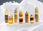 Yellow fluorite obelisk tower crystal from GemstoneGO, showcasing a smooth, vibrant yellow mineral with natural crystal formations.