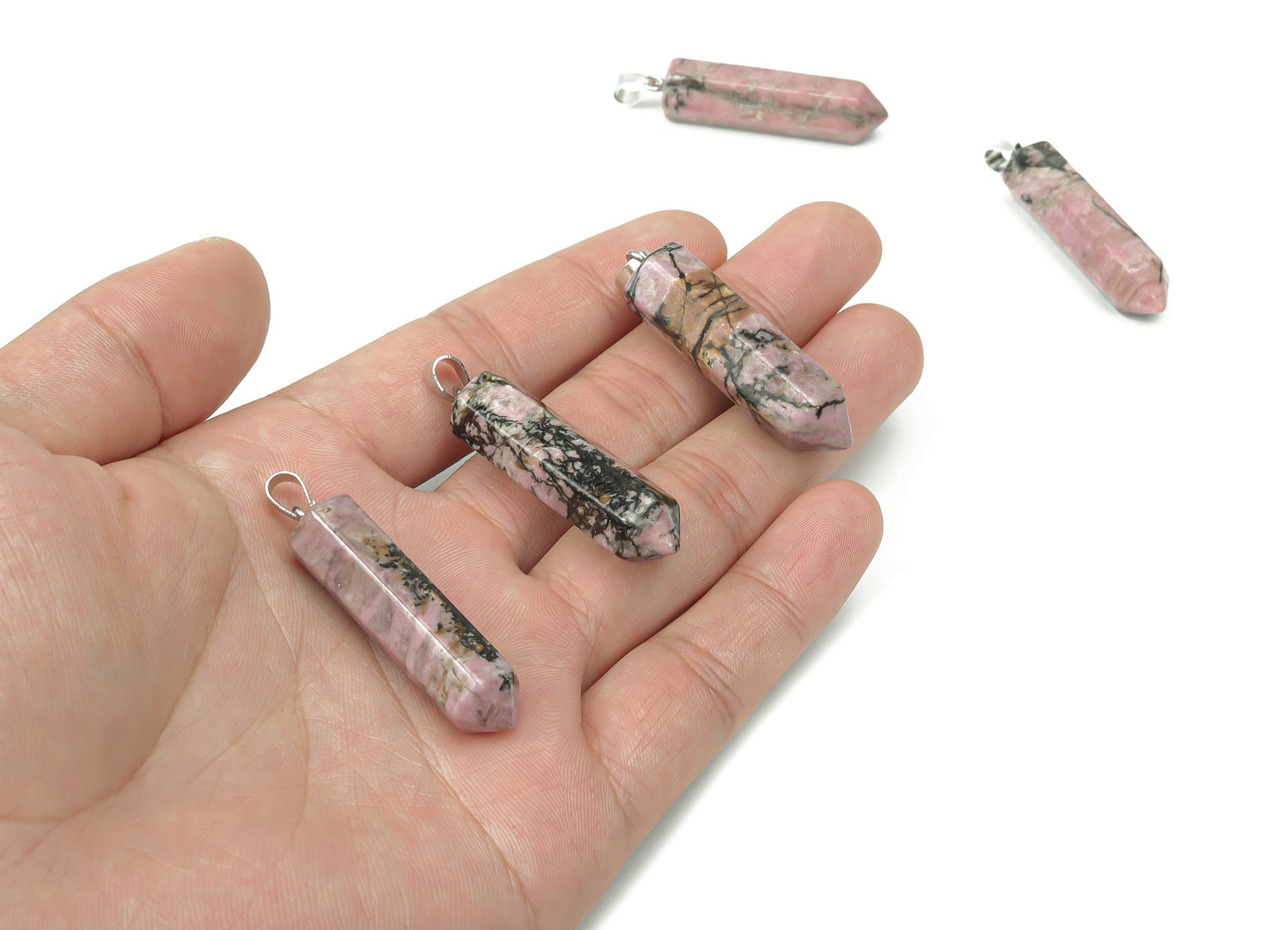 Rhodonite point crystal pendant from GemstoneGO, featuring a polished pink and black gemstone for jewelry making.