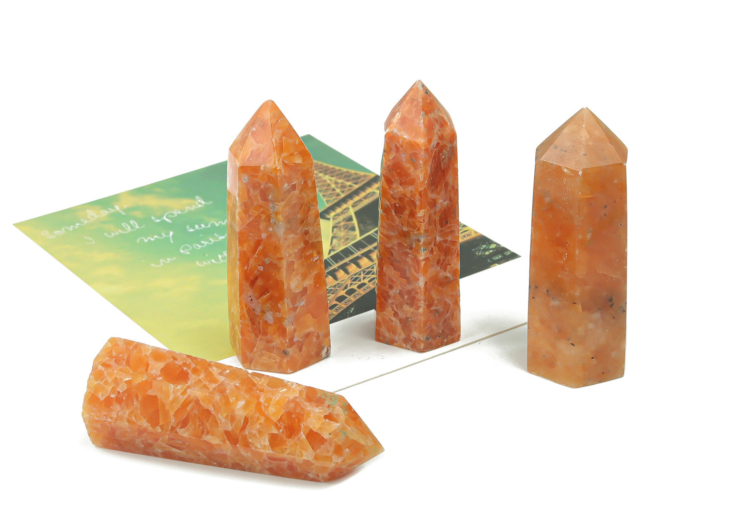 Sunstone obelisk tower crystal from GemstoneGO, showcasing a polished orange gemstone with natural striations and a pointed tip.