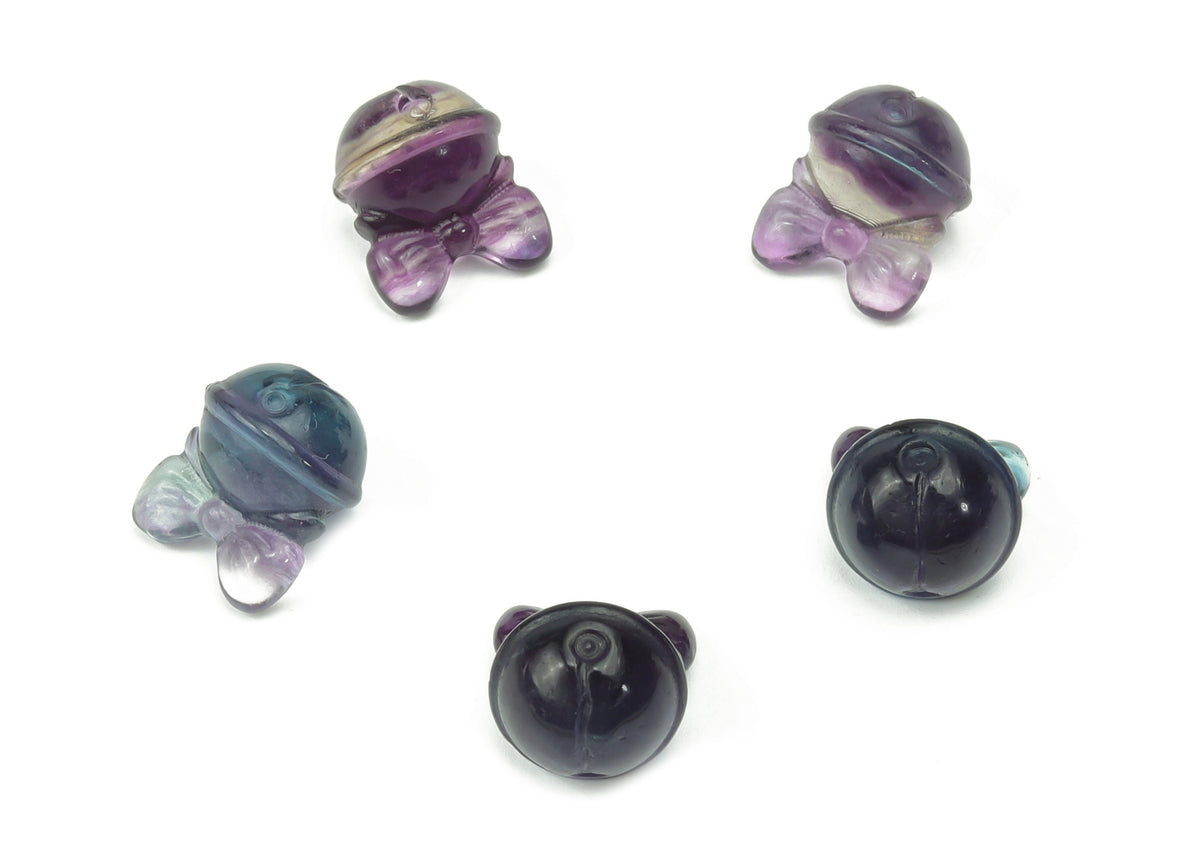 Close-up of a vibrant green and purple fluorite crystal carving gemstone from GemstoneGO, showcasing its smooth polished surface.