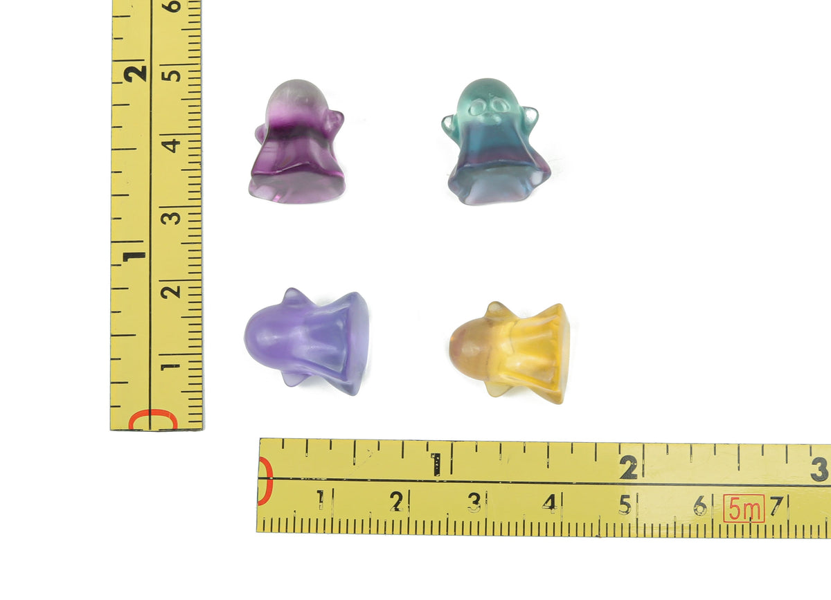 Small fluorite ghost gemstone carving from GemstoneGO, detailed purple and green mineral sculpture on a neutral background.