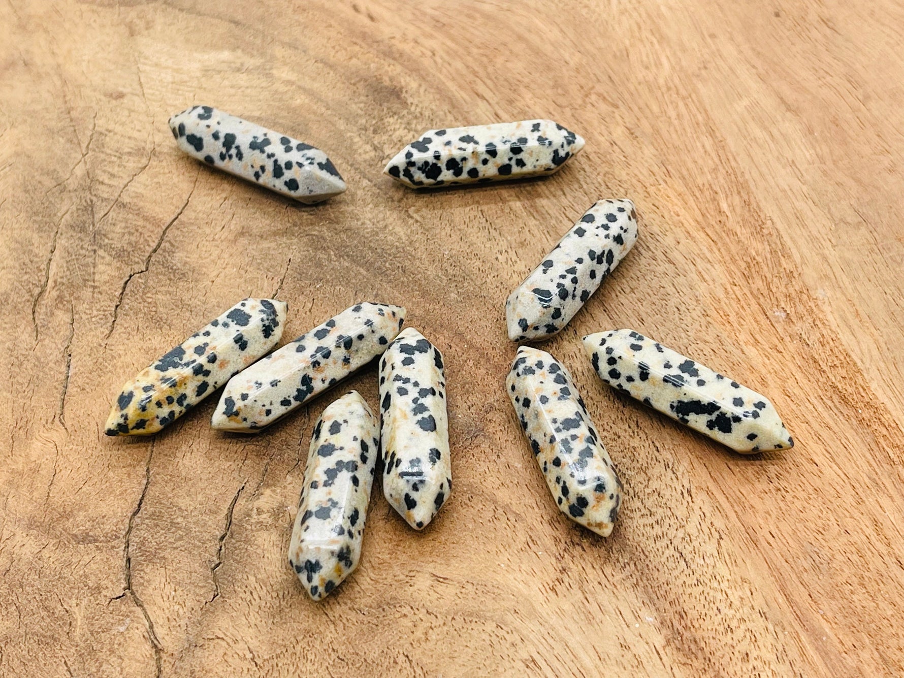 Dalmatian Jasper carved terminated point gemstone, 33mm, from GemstoneGO, showcasing black spots on a cream background.
