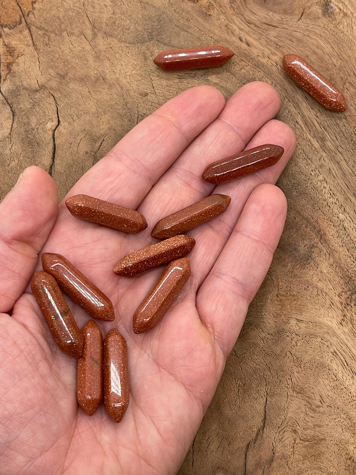 Goldstone terminated carved point gemstone, 33mm, from GemstoneGO, featuring a polished, intricate carved design on a smooth goldstone surface.